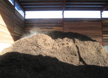 堆肥舎に堆肥を積上げる。